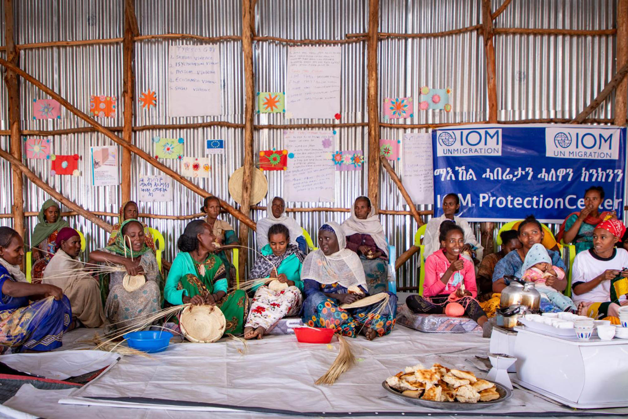 A group of women talking and weaving.