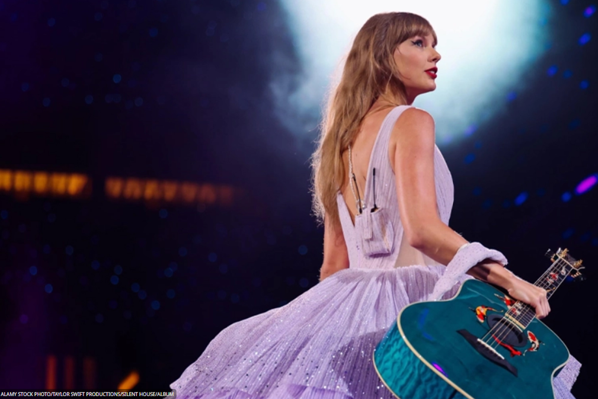 American singer-songwriter Taylor Swift holding a guitar during one of her concerts.
