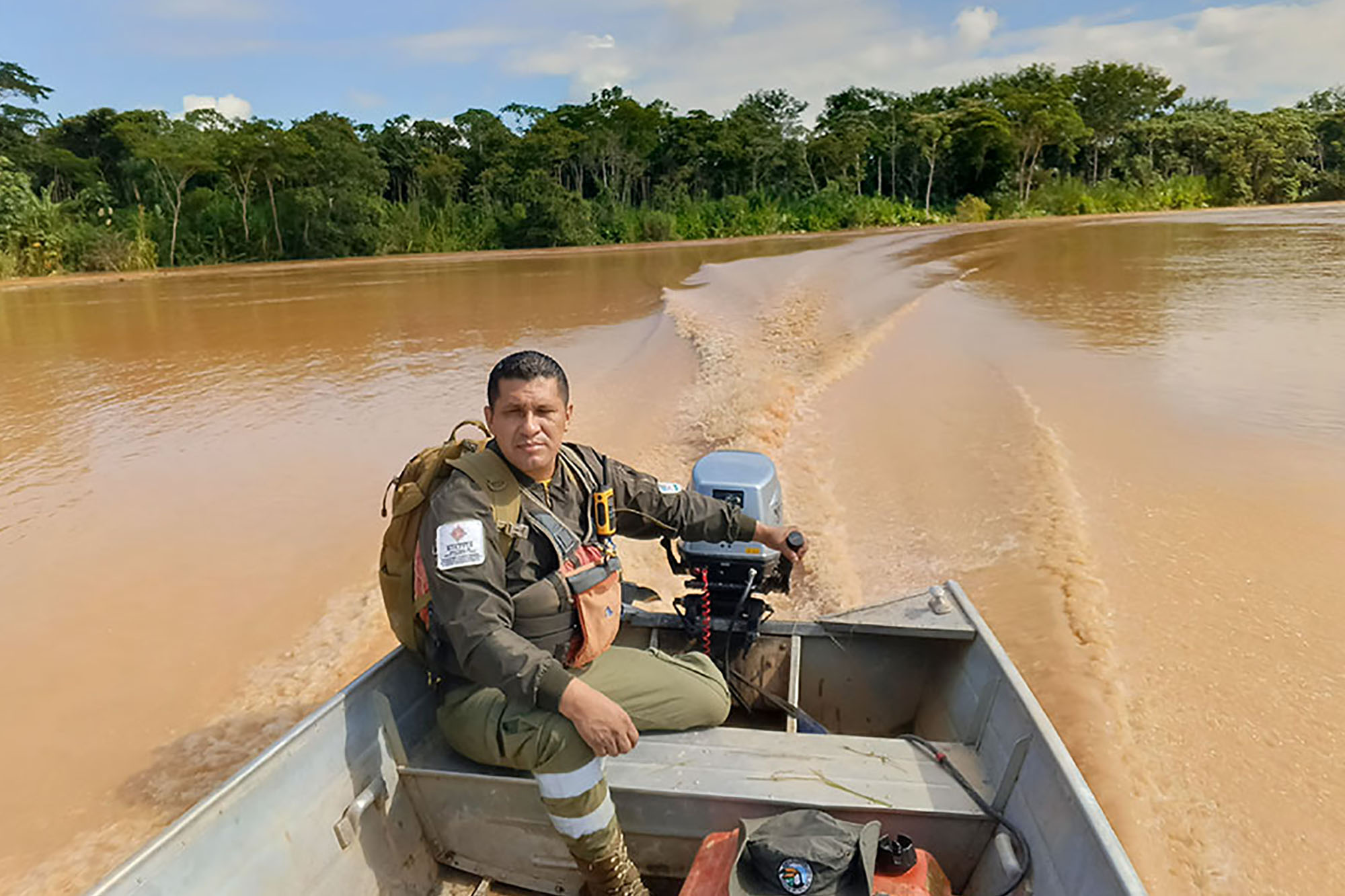 A Bolivian park ranger driving his motorboat in the Bolivian Amazonia.