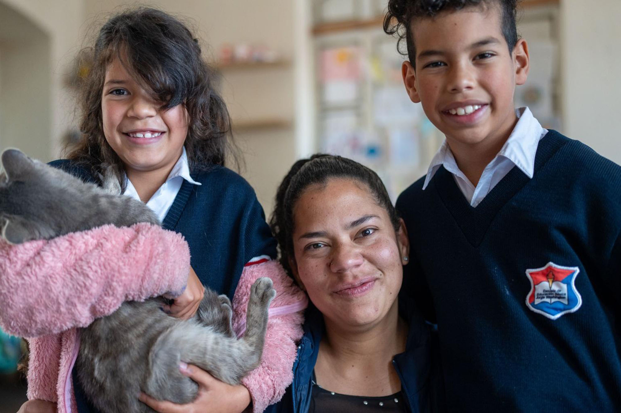 A woman and her two children inside an Equatorian migrant house.  