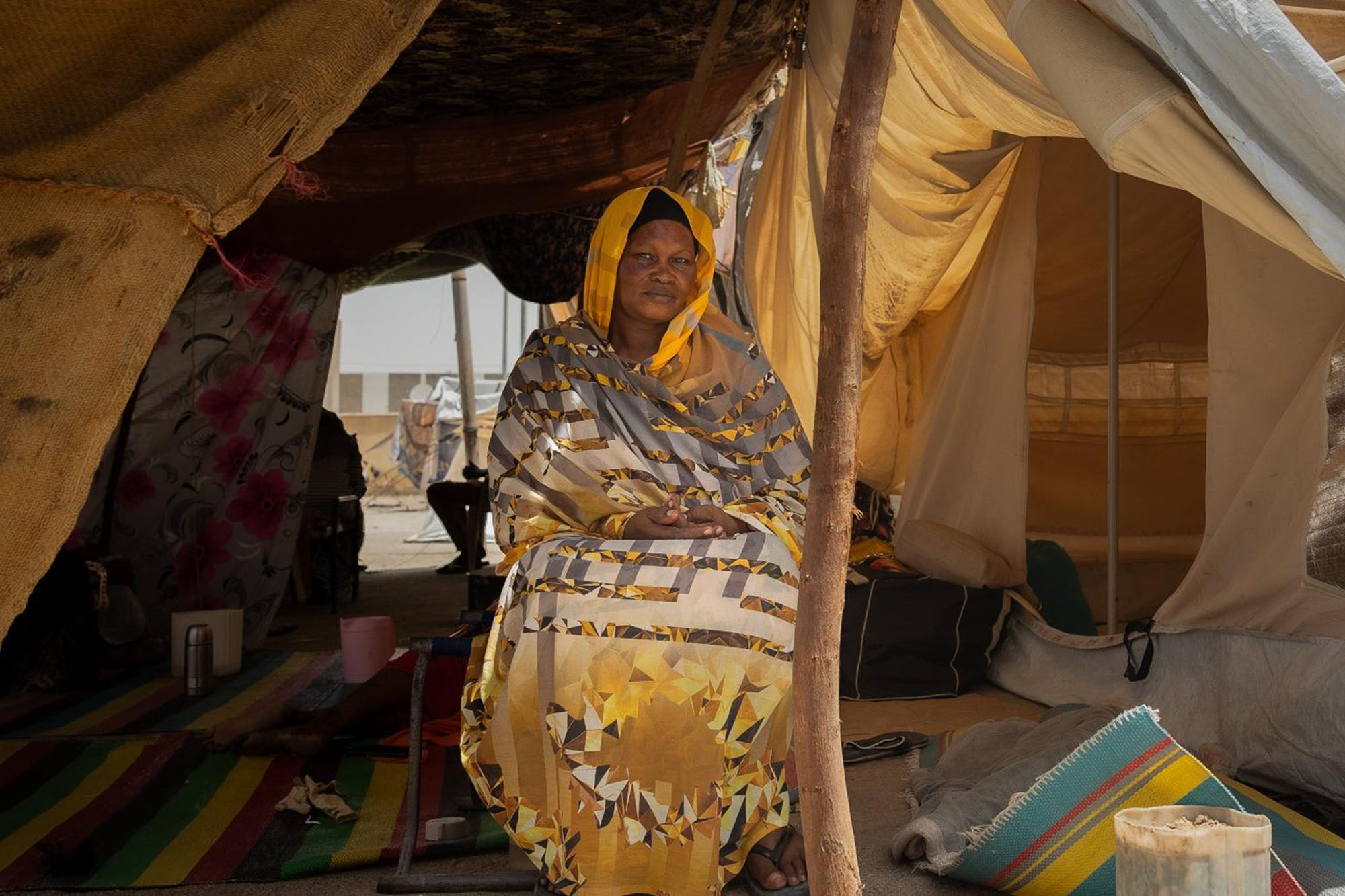 Portrait of a Sudanese woman seated in a tent.
