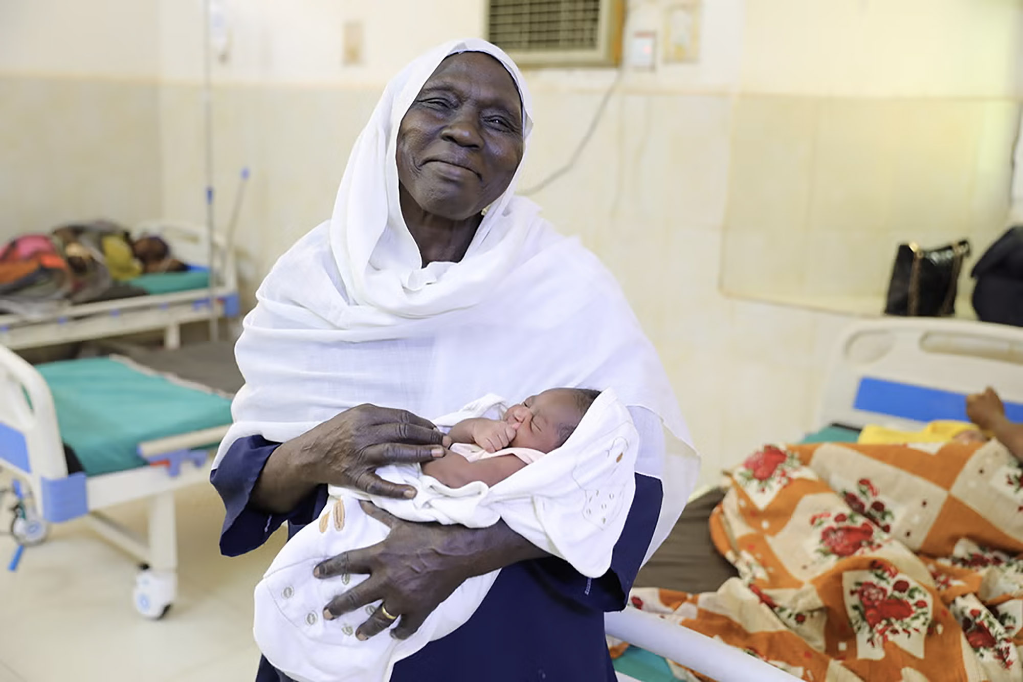 A midwife holding a baby in her lap.