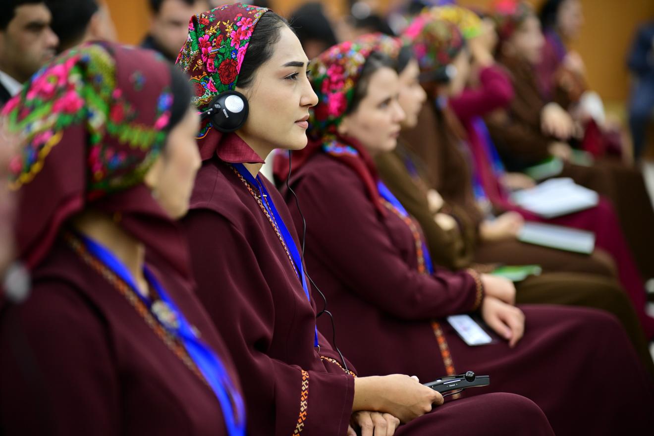 Des femmes portant des habits traditionnels écoutent attentivement une table ronde. 