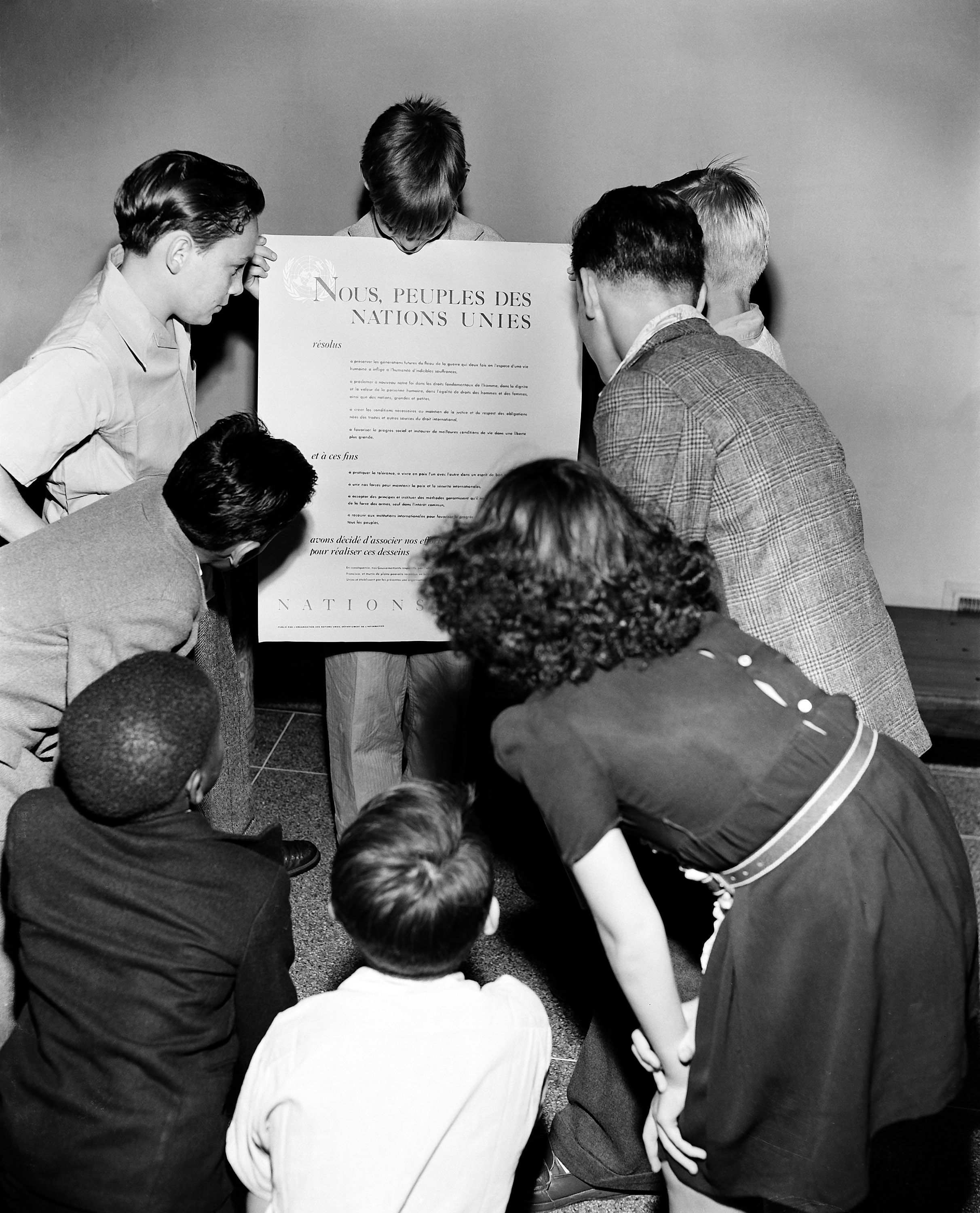 Children are showing the French version of the UN Charter during a visit to Lake Success, the temporary home of the UN from 1946 to 1951