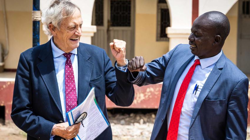 standing next to an African man and making a fist bump 