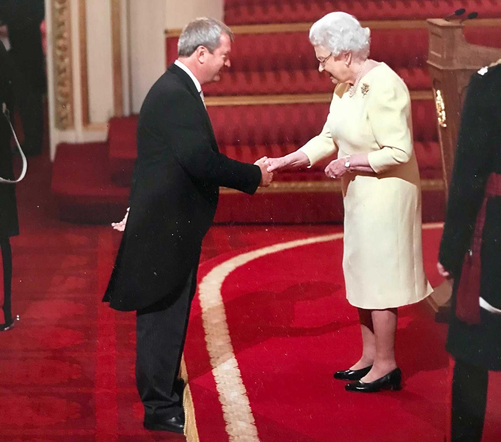 Peter shakes hands with H.M. late Queen Elizabeth II