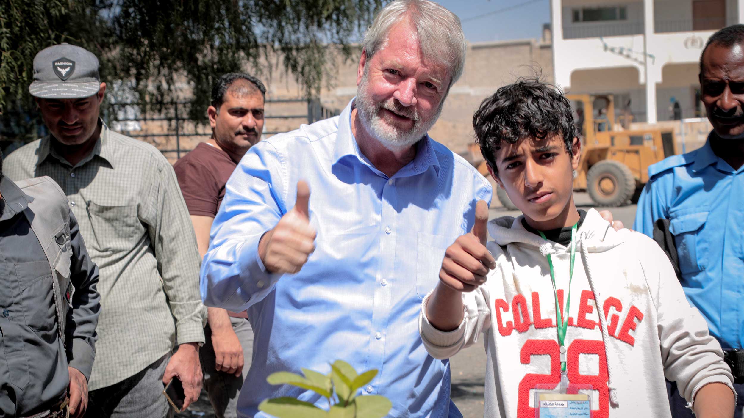 Peter standing shoulder to shoulder with a boy both holding a thumbs up