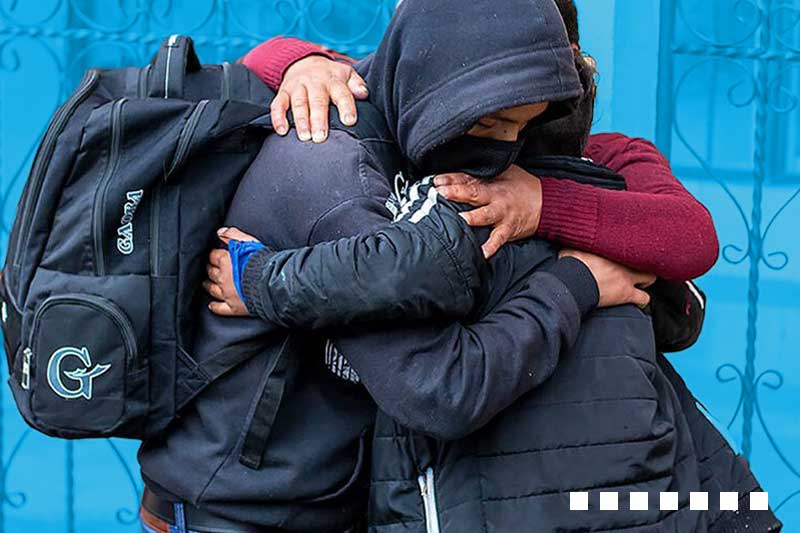 three people embrace
