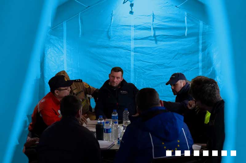 people meeting in a tent with a lightbulb above their heads