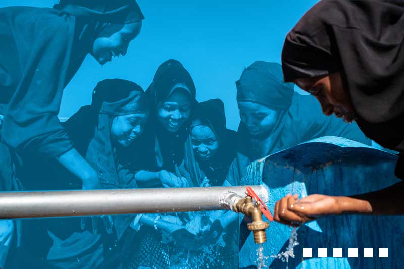 girls wearing veils are drinking water from a pipe