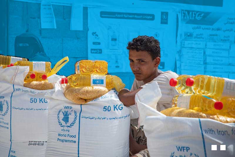 woman and young man sitting next to bags of food