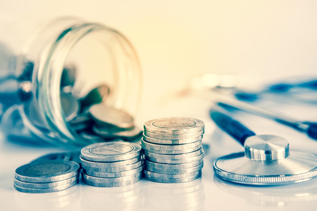 pile of coins and a stethoscope