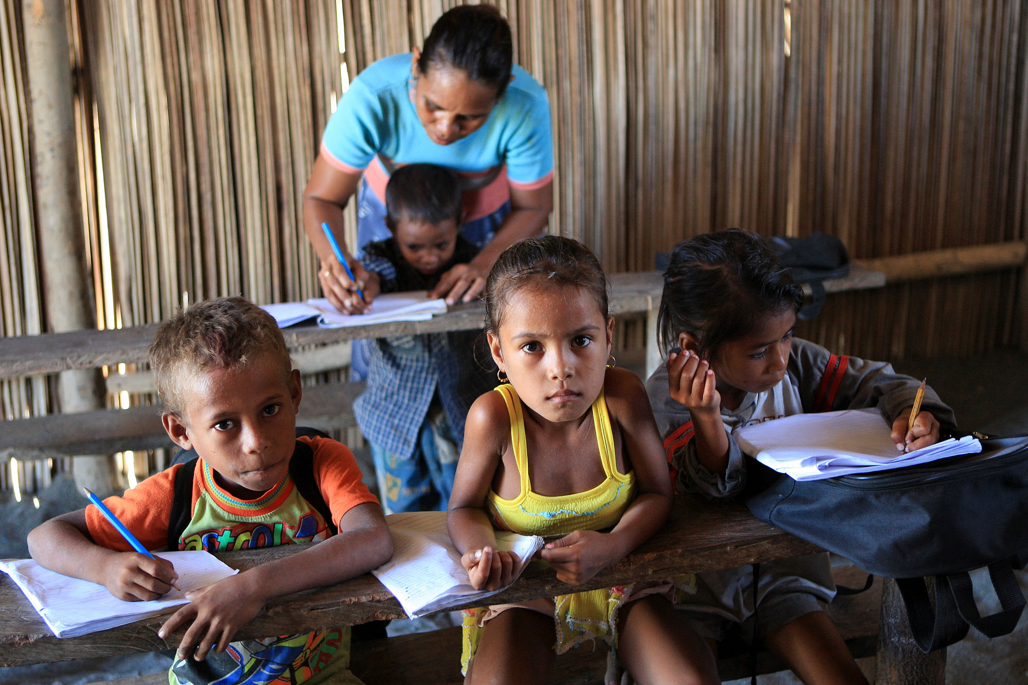 Four children and a teacher in a school in Timor Leste.