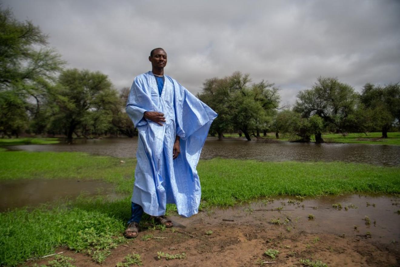 Une personne se tient debout au milieu d'un terrain inondé