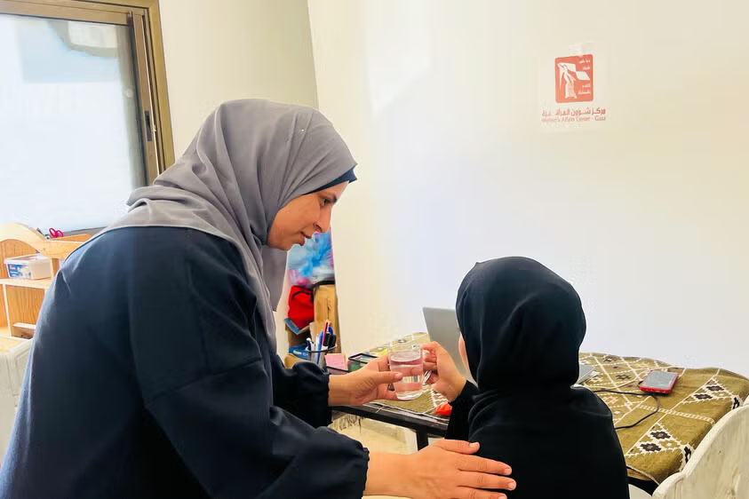 A woman comforting a survivor of conflict in Gaza.