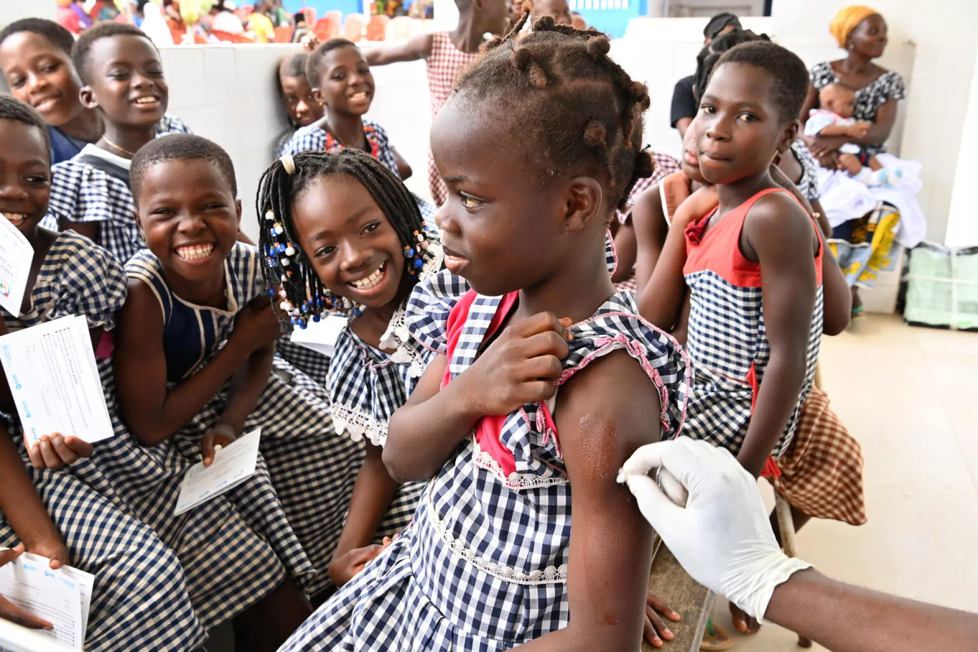 A young girl receiving an injection on her bicep.