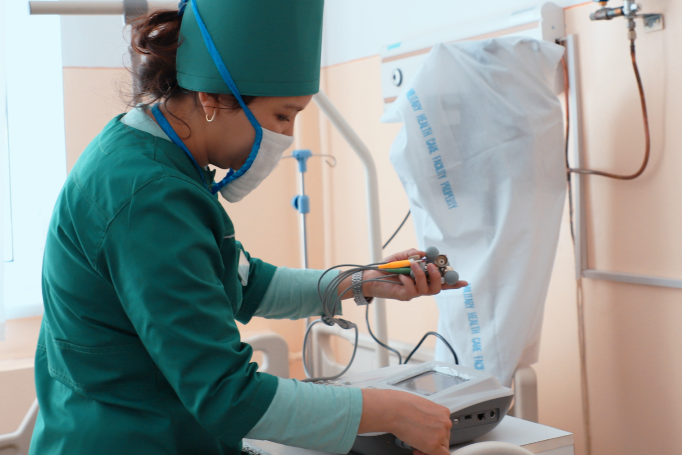 A healthcare worker handling a medical machine.